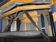 Rückenlehne am achteren Firststab fixiert. Dies ist nötig, weil sonst die Lehne nach vorne klappt und man beim Einsteigen auf ihr zum sitzen kommt. Der verdrehte Fixiergurt am Spant links im Bild kommt daher, weil die Poucher hier die Klemmschnalle verkehrt herum eingenäht haben…grrr…